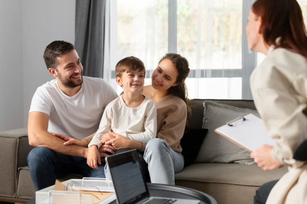 Young family smiling during a counseling session at home with therapist.
