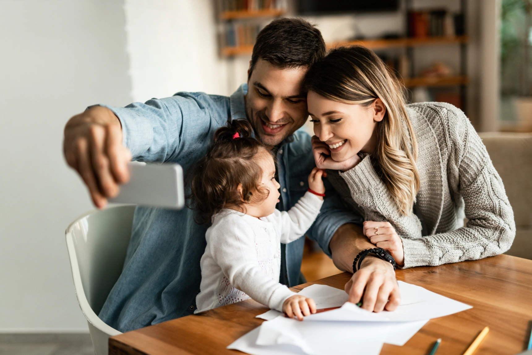 happy-parents-their-small-daughter-taking-selfie-with-mobile-phone-home